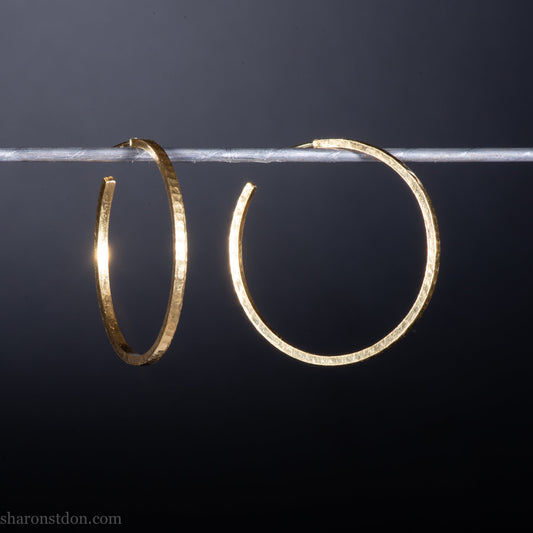 Solid 18k yellow gold hoop earrings set, handmade in North America by Sharon SaintDon.30mm diameter round, 2mm wide, 1.5mm thick, with hammered texture and matte finish.