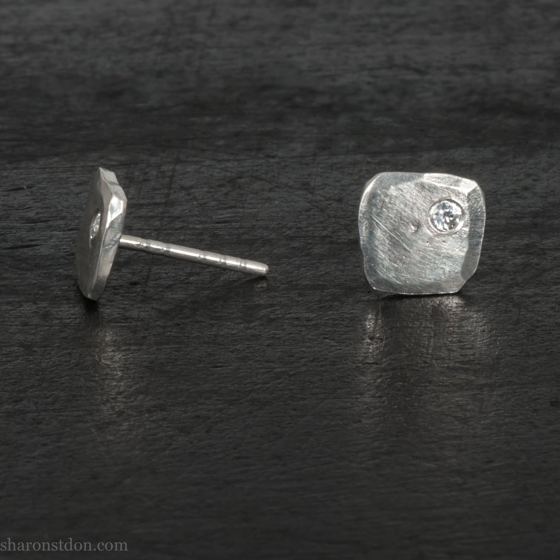 7mm square 925 sterling silver stud earrings with imitation diamond in the corner. Hammered texture with a matte, shiny finish. Handmade by Sharon SaintDon in North America for men or women.