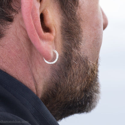 14mm x 2mm small sterling silver hoop earrings, Handmade in North America by Sharon SaintDon. Hammered texture, solid silver with silver posts and backs for men or women, unisex.