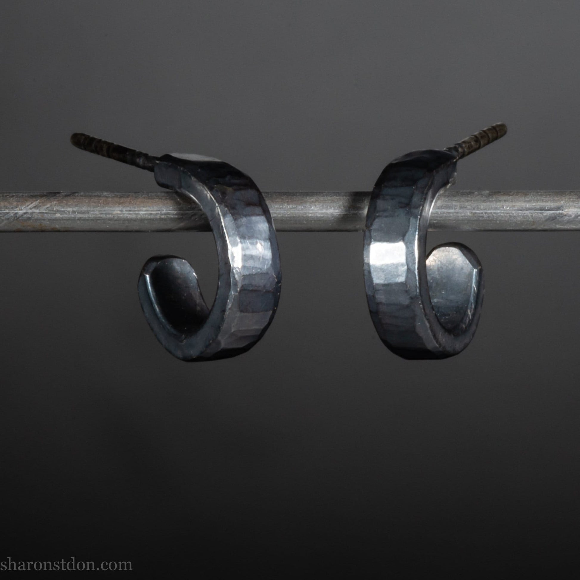 12mm x 3mm small sterling silver hoop earrings, Handmade in North America by Sharon SaintDon. Oxidized black, hammered texture, solid silver with silver posts and backs for men or women, unisex.