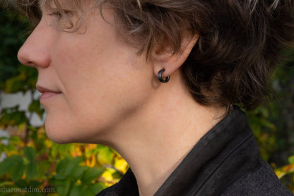 12mm x 3mm small sterling silver hoop earrings, Handmade in North America by Sharon SaintDon. Oxidized black, hammered texture, solid silver with silver posts and backs for men or women, unisex.