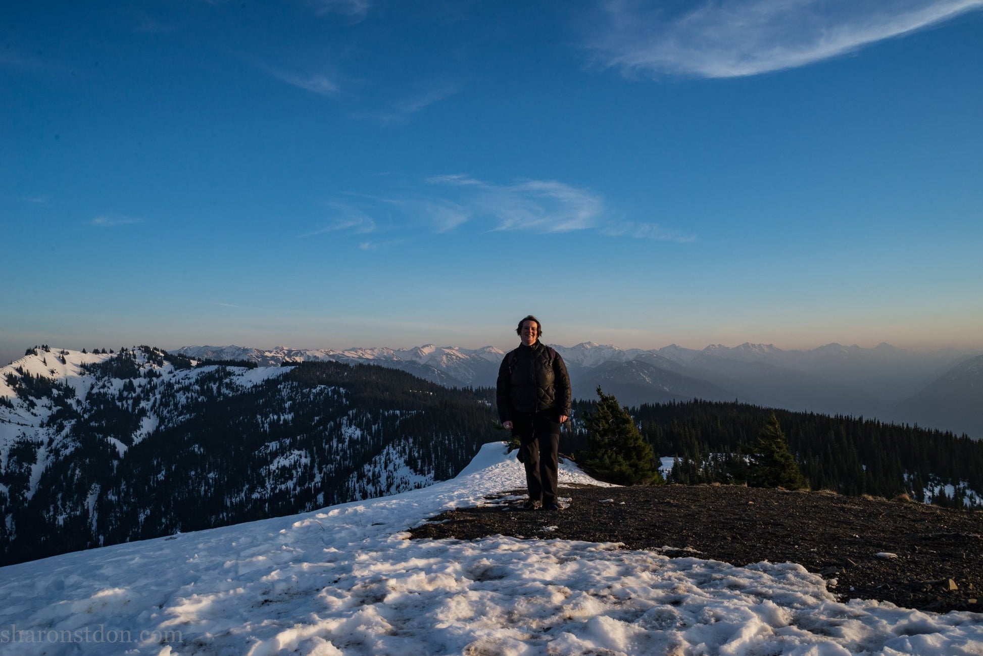 Sharon SaintDon standing on a ridge with snow in Olympic mountains, Washington state, USA.