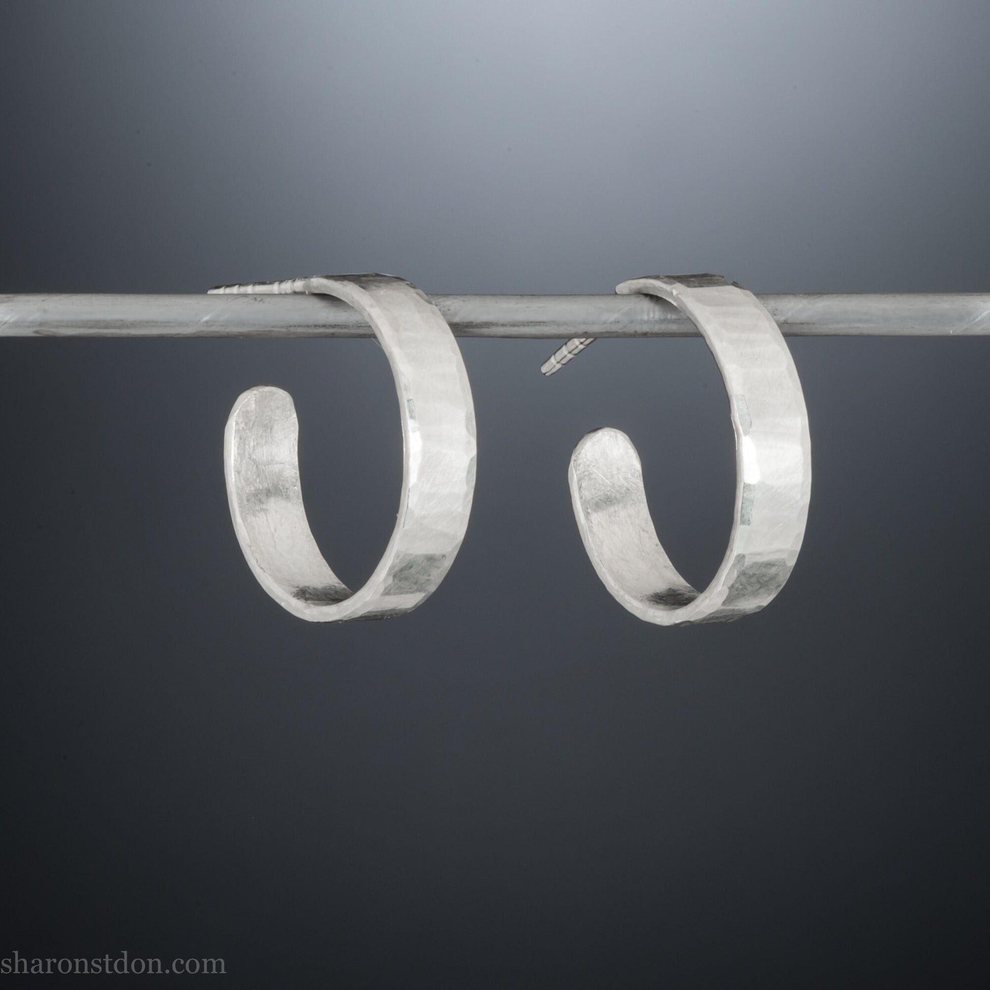 925 sterling silver hoop earrings handmade in North America by Sharon SaintDon. 18mm diameter round, 4mm wide, hammered texture, matte, brushed finish and silver posts and backs.