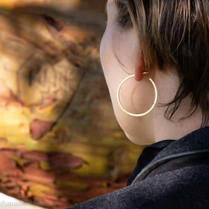 14k yellow gold hoop earrings 30mm diameter, 2mm wide, 1.5mm thick. High quality, handmade with hammered texture, solid gold posts and locking backs.