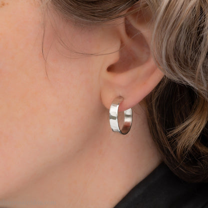 925 sterling silver hoop earrings handmade in North America by Sharon SaintDon. 18mm diameter round, 4mm wide, hammered texture, matte, brushed finish and silver posts and backs.