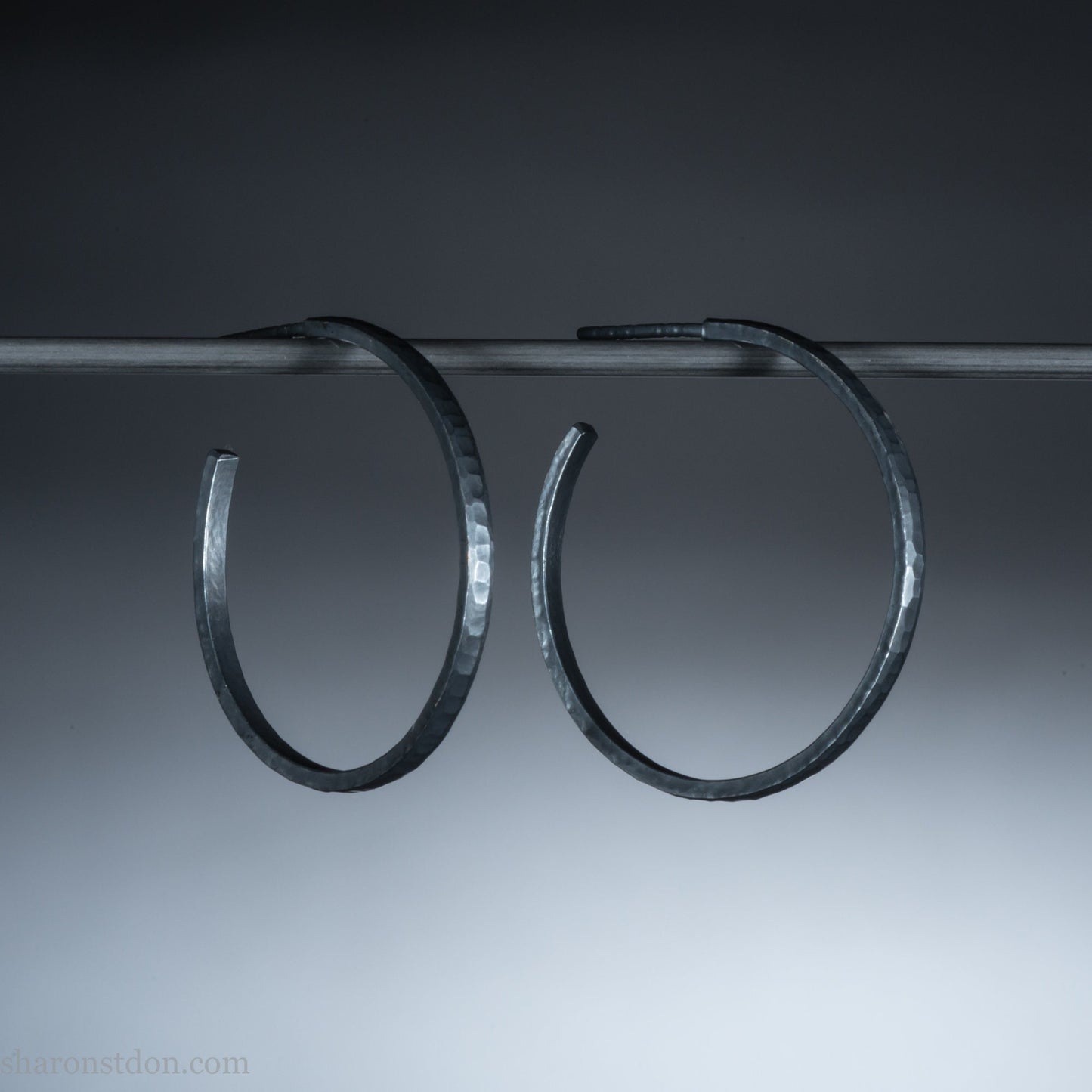 25mm x 2mm Oxidized black 925 sterling silver hoop earrings for women. Hammered solid silver hoops, handmade by Sharon SaintDon in North America.