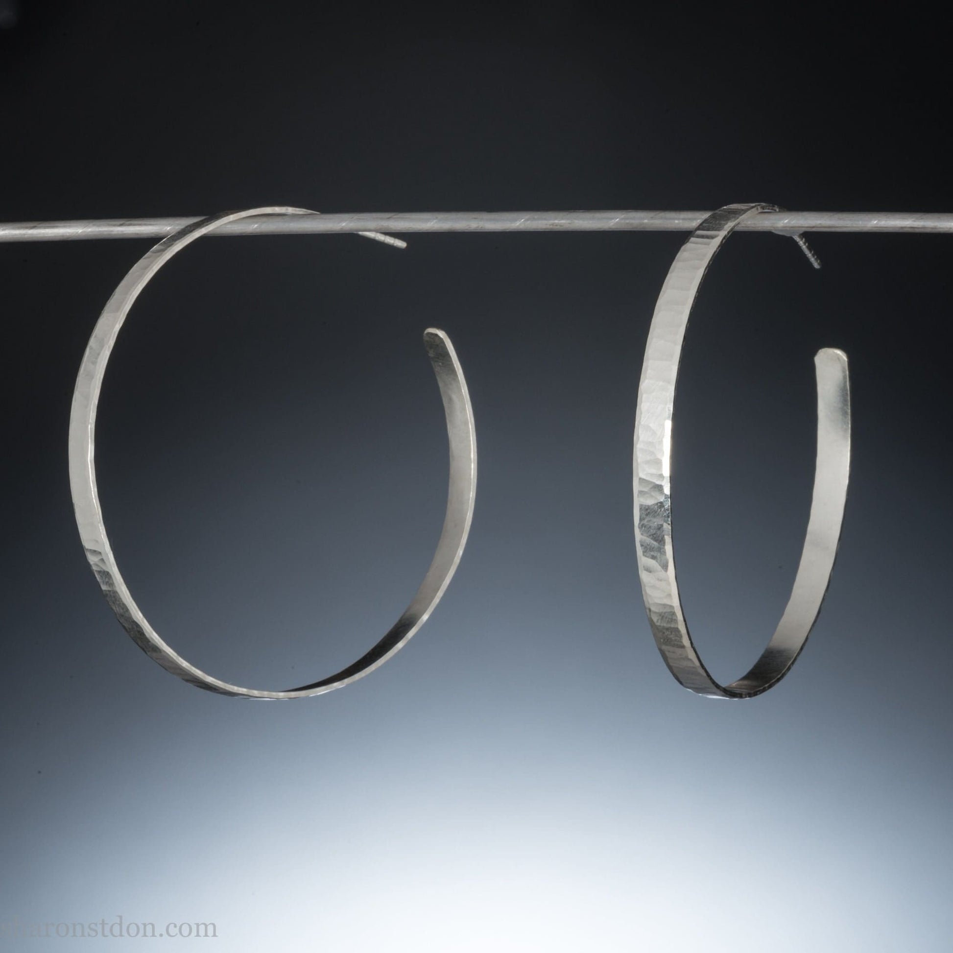 50mm diameter x 5mm, large, wide sterling silver hoop earrings for women. Handmade in North America by Sharon SaintDon. Hammered, wavy, matte texture. Solid silver including silver posts and backs