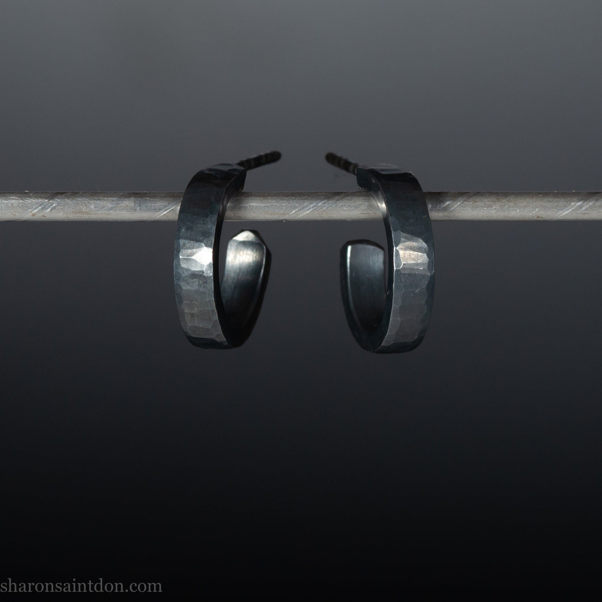 16mm x 3mm wide, handmade 925 sterling silver hoop earrings for men or women. Hammered texture, oxidized black earrings by Sharon SaintDon in North America.
