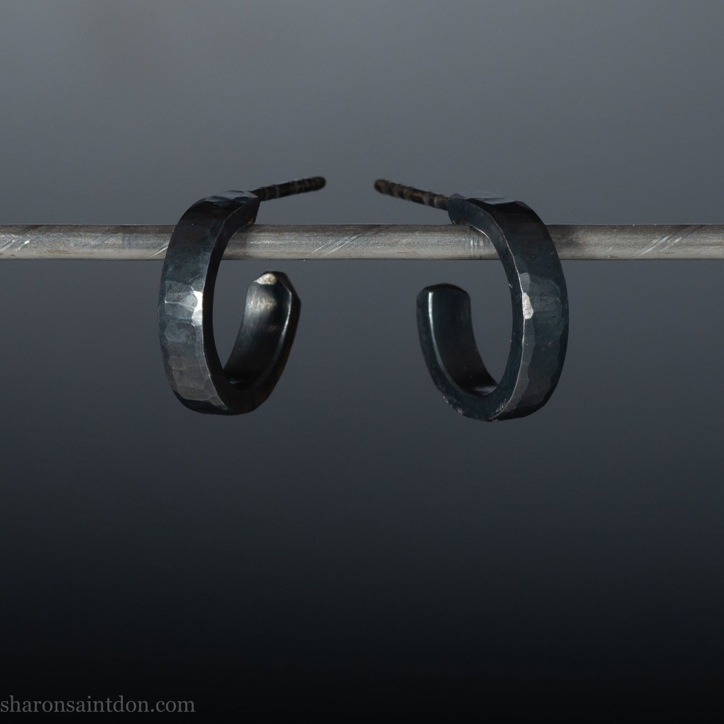 16mm x 3mm wide, handmade 925 sterling silver hoop earrings for men or women. Hammered texture, oxidized black earrings by Sharon SaintDon in North America.