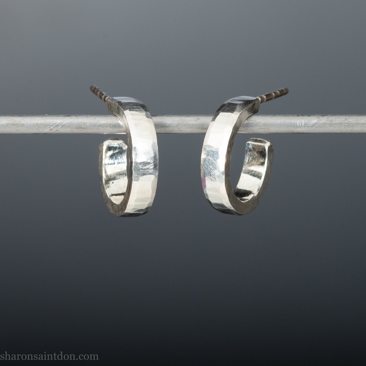 14mm x 3mm small sterling silver hoop earrings, handmade in North America by Sharon SaintDon. Hammered texture, solid silver with silver posts and backs for men or women, unisex.