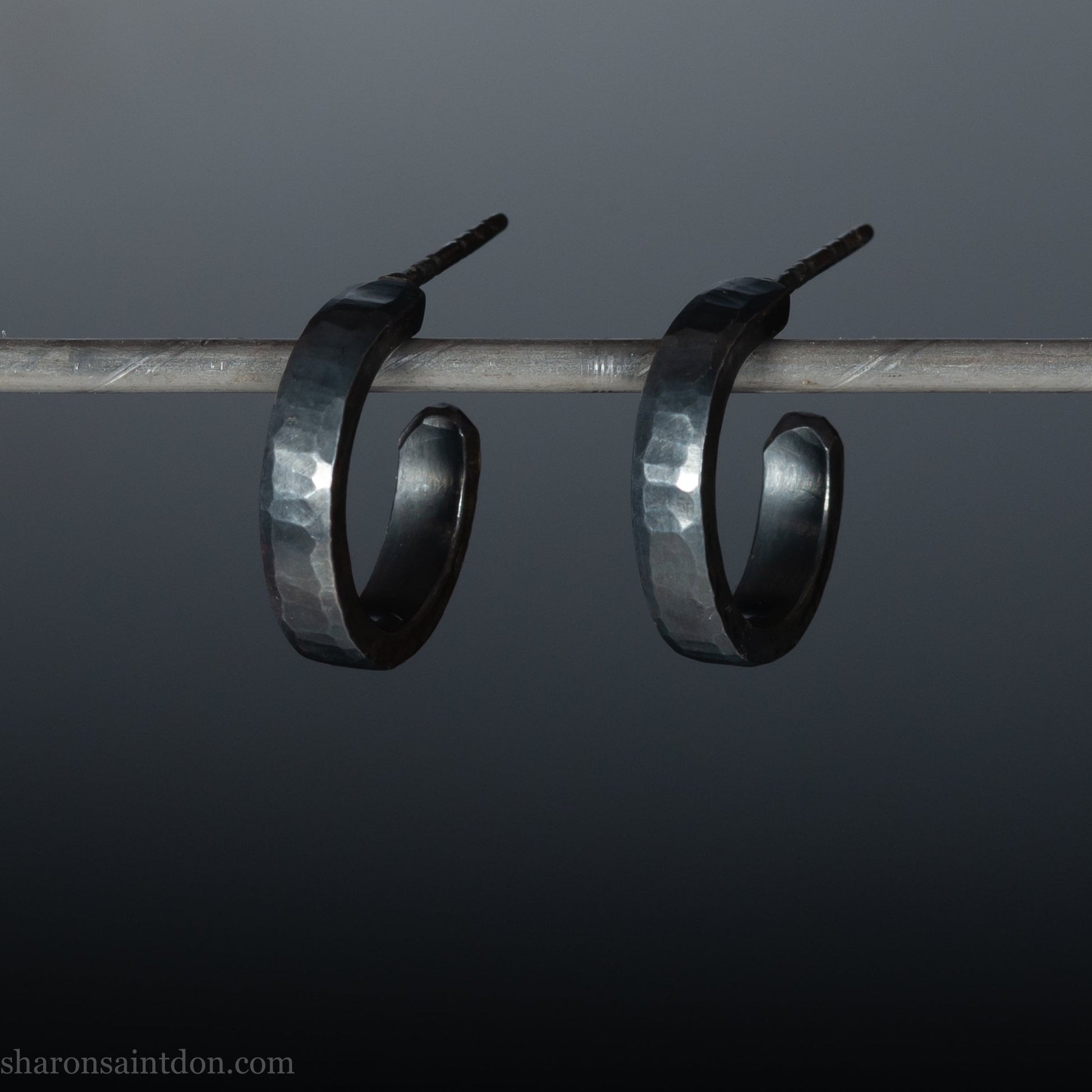 925 sterling silver hoop earrings for men or women, handmade in North America by Sharon SaintDon. 18mm diameter x 3mm wide, small, round, oxidized black with hammered texture.
