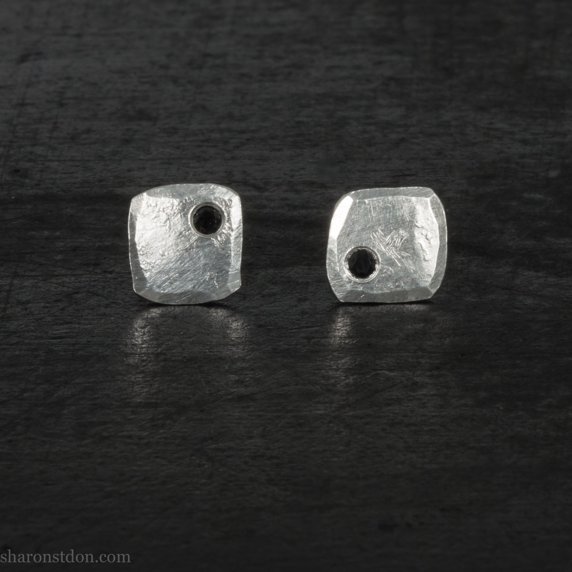7mm square 925 sterling silver stud earrings with a black spinel gemstone in the corner. Hammered texture with a matte, brushed, shiny finish. Handmade by Sharon SaintDon in North America for men or women.