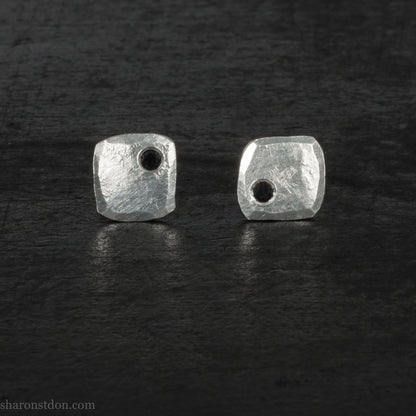 7mm square 925 sterling silver stud earrings with a black spinel gemstone in the corner. Hammered texture with a matte, brushed, shiny finish. Handmade by Sharon SaintDon in North America for men or women.