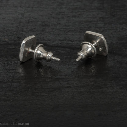 7mm square 925 sterling silver stud earrings with a black spinel gemstone in the corner. Hammered texture with a matte, brushed, shiny finish. Handmade by Sharon SaintDon in North America for men or women.