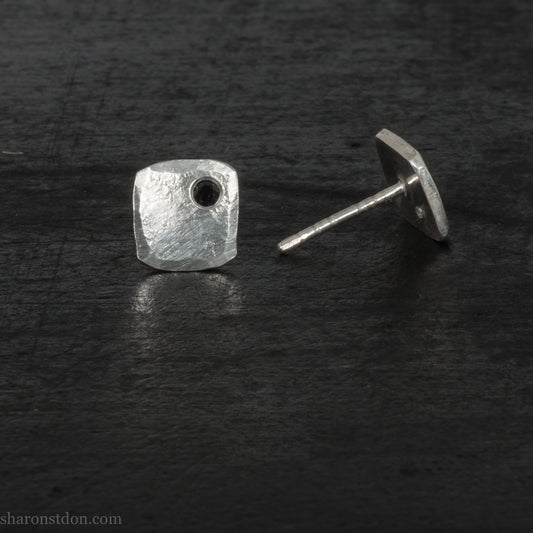 7mm square 925 sterling silver stud earrings with a black spinel gemstone in the corner. Hammered texture with a matte, brushed, shiny finish. Handmade by Sharon SaintDon in North America for men or women.