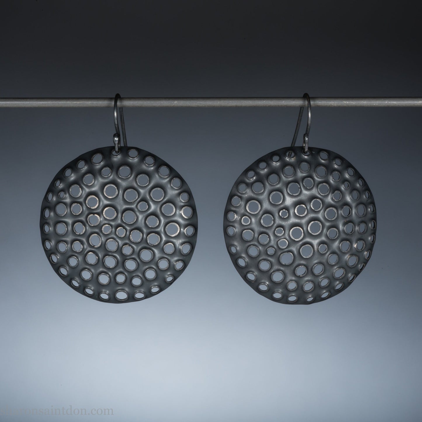 Handcrafted 38mm round sterling silver dangle earrings with oxidized black finish and hand-punched holes texture.
