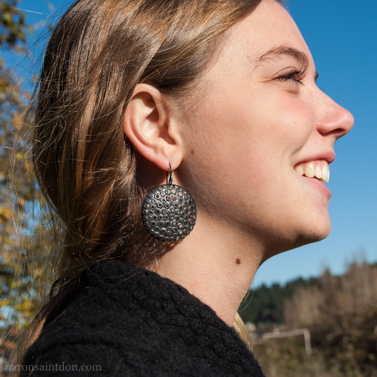 Handcrafted 38mm round sterling silver dangle earrings with oxidized black finish and hand-punched mesh holes.