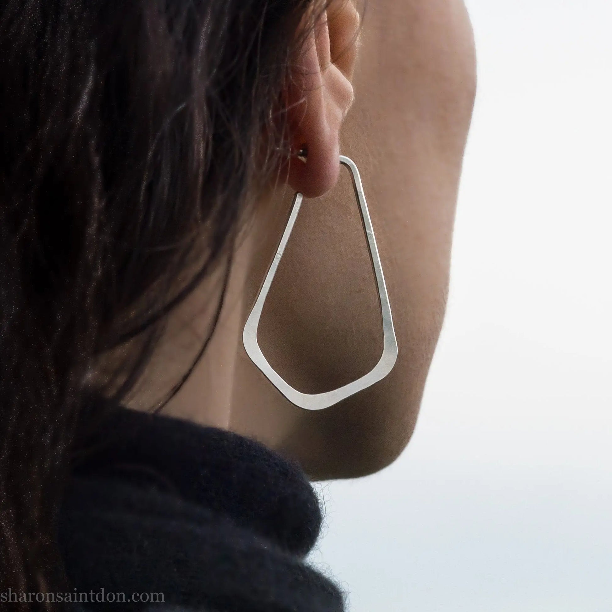 Solid 925 sterling silver teardrop elongated shape hoop earrings,  hammered matte finish and, 50x32mm. Worn on an ear.