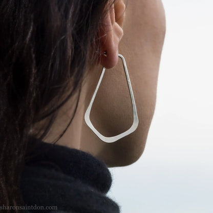 Solid 925 sterling silver teardrop elongated shape hoop earrings,  hammered matte finish and, 50x32mm. Worn on an ear.