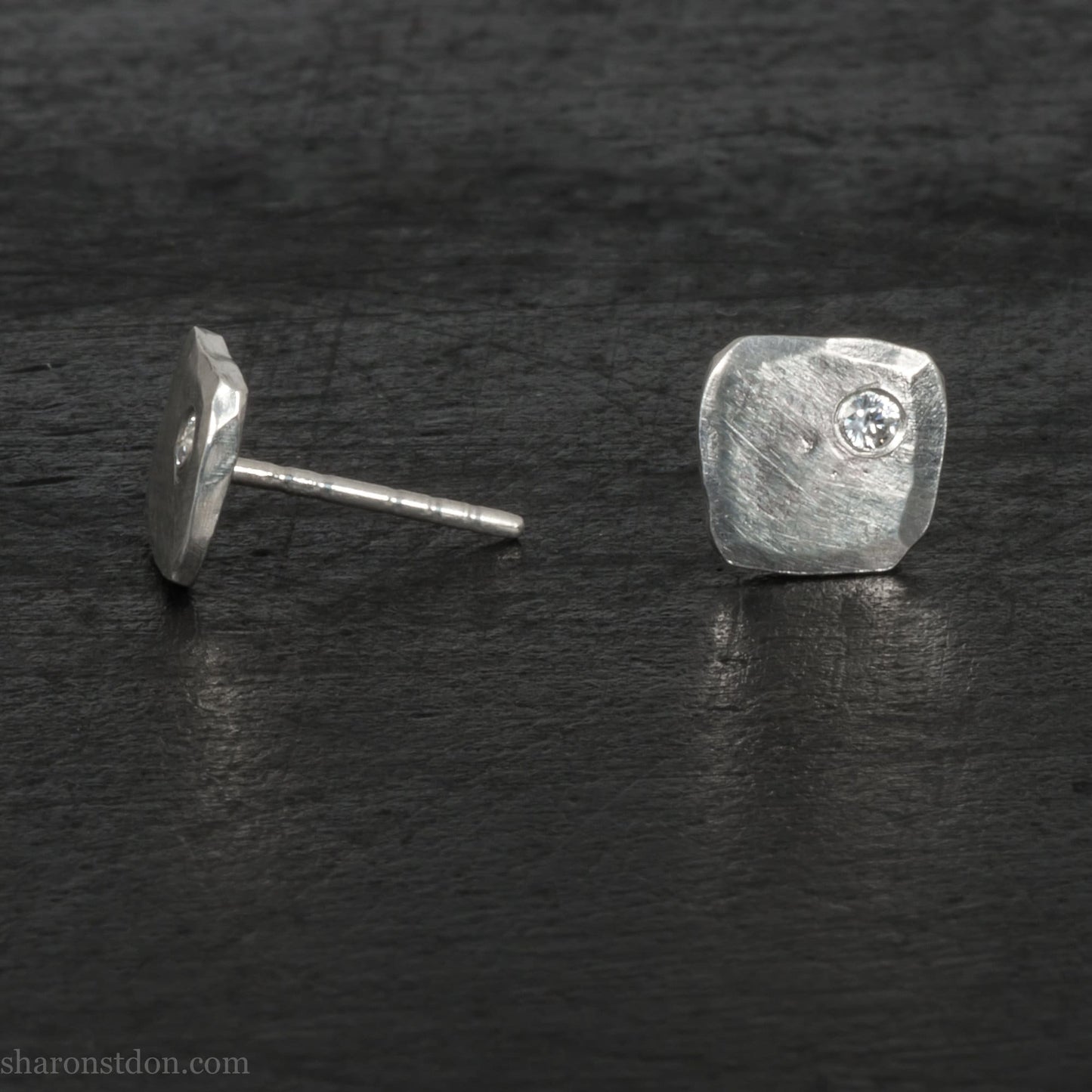925 sterling silver square stud earrings with cubic zirconia gemstones. Handmade by Sharon SaintDon in North America. 7mm x 7mm, 1.5mm thick with 2mm round, flush set stone in corner. Silver posts and backs.