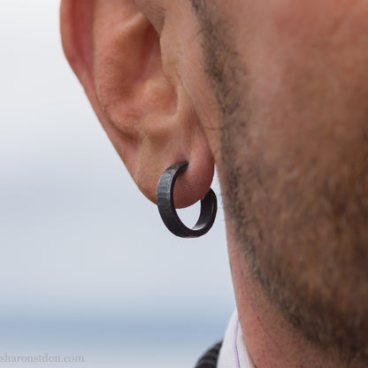 18mm x 4mm small sterling silver hoop earrings for for men or women, unisex. Handmade in North America by Sharon SaintDon. Hammered texture,solid silver with silver posts and backs  oxidized black minimalist earrings